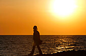 Eine Frau spaziert am Strand bei Sonnenuntergang, Wellfleet Hafen, Cape Cod, Massachusetts, USA