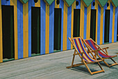 Deck chairs in front of changing rooms at the sea