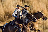 cowgirl and cowboy riding, Oregon, USA