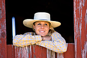 Cowgirl schaut aus Scheunenfenster, Wilder Westen, Oregon, USA
