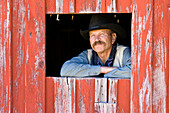 Cowboy schaut aus Scheunenfenster, Wilder Westen, Oregon, USA