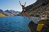 Junge Frau springt in Lago d'Orsino, Gotthard, Kanton Tessin, Schweiz, MR