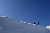 Two back-country skiiers on snow cornice, Tschachaun, Lechtal Alps, Vorarlberg, Austria