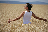 Mid adult woman meditating in a corn field, , Carinthia, Austria