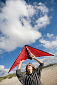 Junge am Strand lässt Drachen steigen, Insel Sylt, Schleswig-Holstein, Deutschland