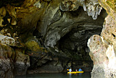 Seekanu bei Einfahrt in eine Höhle in Kalsteinfelsen, Bucht von Phang Nga, Thailand