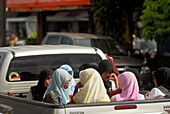 Muslim women sitting in the back of a pickup, Trang, Thailand