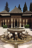 Löwenhof mit Brunnen und Arkaden mit schlanken Marmorsäulen im maurischen Fürstenpalast Alhambra, Granada, Andalusien. Spanien