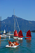 Tretboot mit küssendem Pärchen und Segelboote, Mondsee, Salzkammergut, Salzburg, Österreich
