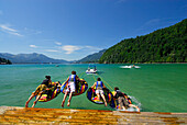 Four young people tube riding on lake Abersee (lake Wolfgangsee), Salzkammergut, Salzburg, Austria