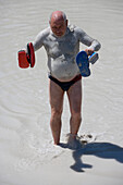 Mann läuft durch Fanghi Schlammbad auf Insel Vulcano, nahe Lipari, äolische Inseln, nahe Sizilien, Italien, Europa