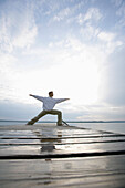 Man practising yoga at Lake Starnberger, Muensing, Bavaria, Germany, MR