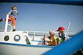 Children playing in a boat on a playground, Lake Starnberg, Bavaria, Germany