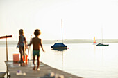 Zwei Kinder auf einem Steg am Wörthsee, Bayern, Deutschland, MR