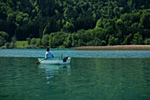 Fisherman in a boat on Lake Tegernsee, Upper Bavaria, Bavaria, Germany