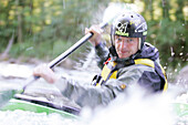 Man, Kayak guide, in a kayak, kayak weekend for beginners on the Mangfall river, Upper Bavaria, Germany