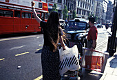 Woman hailing a taxi, Oxford Street, London, London, England, United Kingdom