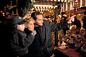 Family visiting Christmas market in the evening, Schiller Square, Suttgart, Baden-Wurttemberg, Germany