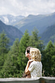 Young couple standing in mountain pasture, Heiligenblut, Hohe Tauern National Park, Carinthia, Austria