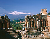 Etna Volcano and ruins of the old Greek theatre. Taormina. Sicily. Italy