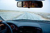 Auto-Cockpit mit Fahrer im Rückspiegel, Island