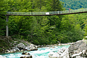 Mountain biker on plank bridge over river Soca, Triglav National Park, Slovenia