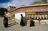 Prayer mills. Potala Palace in background. Lhasa. Tibet. China.