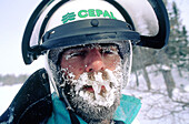 Man with ice covered face after a snowmobile race in winter. Quebec. Canada