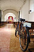 Lonesome worshipper having secured his bike in a baroque church. Antigua Guatemala, Guatemala