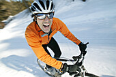 Mann fährt Mountainbike im Schnee, Steiermark, Österreich