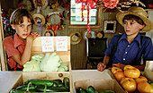 Amish boys selling vegetables in their family farm. Pennsylvania, USA