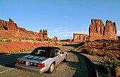 Tourist in convertible car taking pictures, Arches National Park. Utah, USA