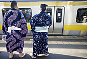 Two sumo waiting for the JR train at Ryogoku station. Tokyo. Japan