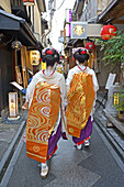 Maikos (geisha apprentices) walking to their evening appointment in the traditional quarters of Gion and Pontocho. Kyoto. Kansai, Japan