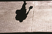 Shadows of a transit user entering Scott Road Skytrain Station. Surrey. British Columbia, Canada