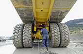 Worker cleaning dumper-truck to carry marl from quarry to cement plant