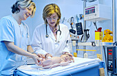 Pediatrician and nurse examinating baby at hospital