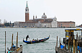 Gondola beside Riva degli Schiavoni and San Giorgio Maggiore church in background. Venice. Veneto, Italy