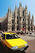 Yellow cab in front of Duomo (cathedral). Milan. Italy