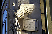 Street sign Rua de Sao Nicolau and carved eagle at a wall corner. Alfama quarter. Lisbon. Portugal