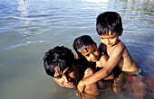 Father and sons bathing in the sea on Sunday. Trou-Aux-Biches. West Coast. Mauritius