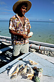 Fisherman selling shells on his small boat. Trou-Aux-Biches beach. South West. Mauritius