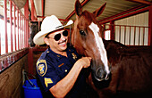 Policeman and horse in stable. Stockyards, Fort Worth. Texas, USA