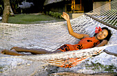 Local Woman ( vahine ) relaxing on a hammock. Bora Bora, Leeward Islands. French Polynesia
