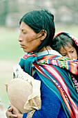 Woman carrying child in her poncho. Cuzco. Peru