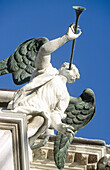 Angel musician playing trumpet on top of a church. Venice. Italy.
