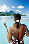 Young man holding his ukulele guitar. Bora Bora. Leeward islands. Society archipelago. French Polynesia (model released)
