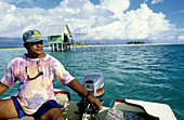 Fisherman and black pearl grower (farm at back on stilts in the lagoon). Tikehau Atoll . Tuamotus archipelago. French Polynesia (MR)
