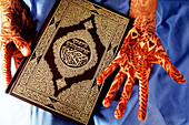 Koran and henna painted hands. Morocco
