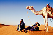 Men and camel in the dunes of Tindou, South Zagora. Morocco